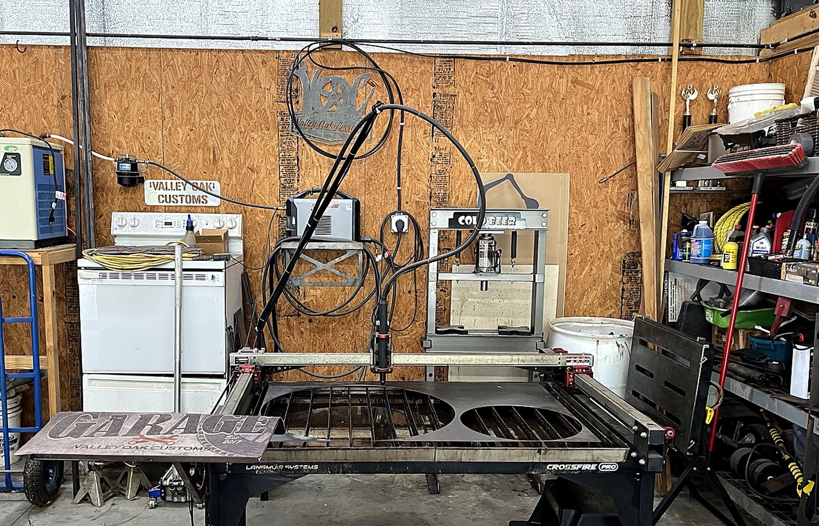 Valley Oak Customs CNC plasma table in the shop with a GARAGE sign project on the table